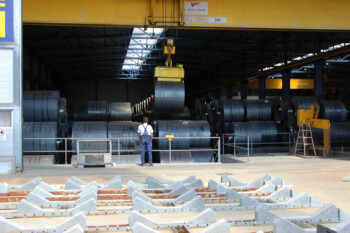 Die Stahlcoils werden mit Magnetkran in die Lagerhalle verbracht. Die Stahlcoils werden mit Magnetkran in die Lagerhalle verbracht.